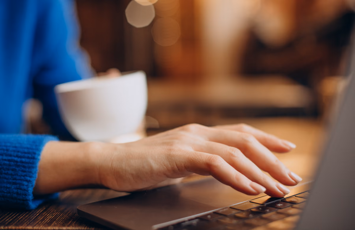 Primer plano de manos escribiendo en el teclado de un portátil