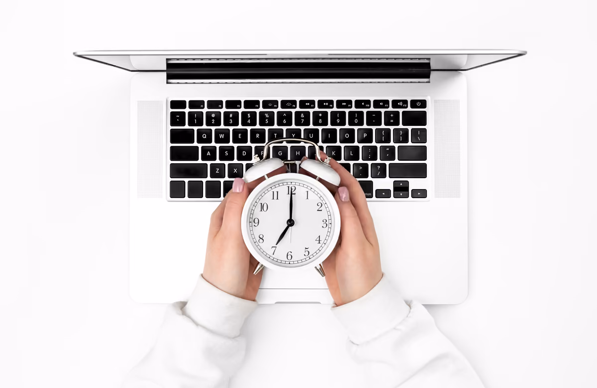 Reloj despertador sobre un portátil visto desde arriba