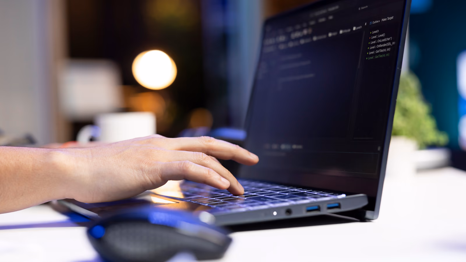 Persona escribiendo código en un portátil para bloquear la IA en tu web
